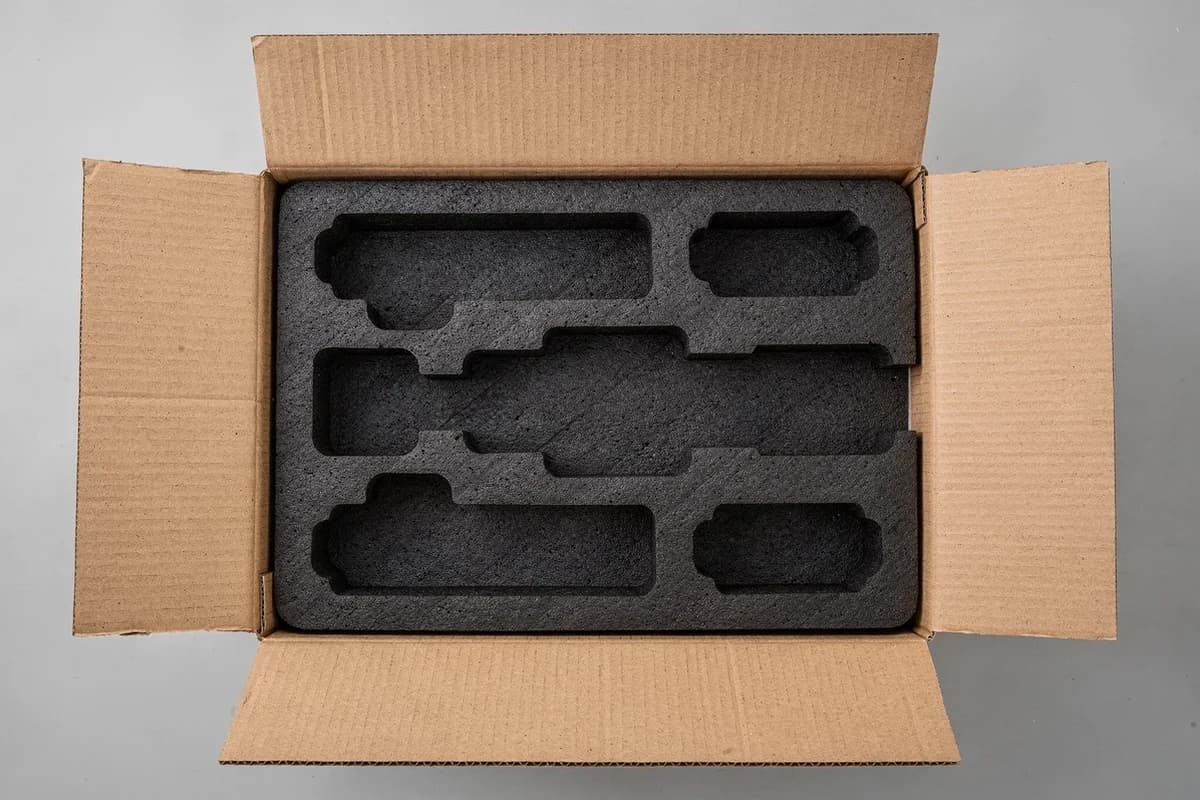 Foam packaging insert with product-shaped cavities in a corrugated box