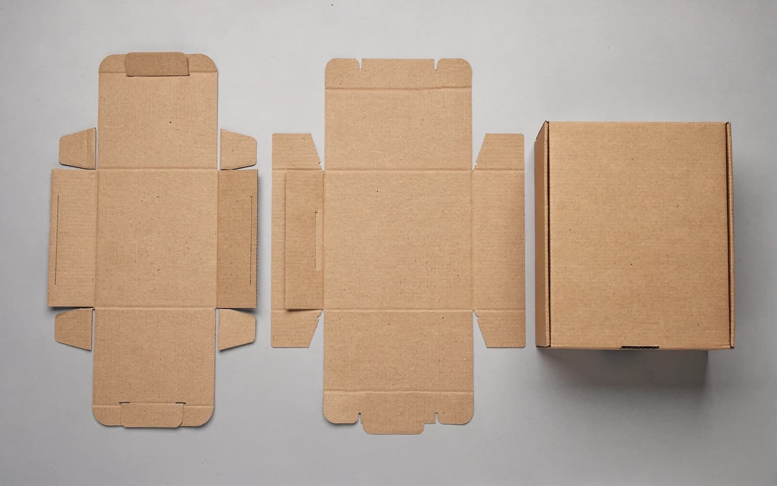 Unfolded corrugated box blanks with crease lines and one folded sample box