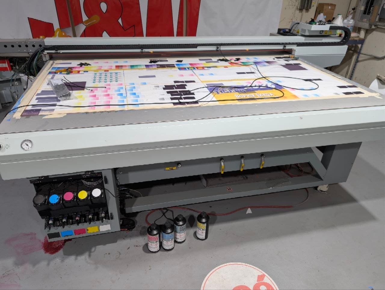 Océ Arizona 365 with a color test print on the bed and Lipla ink bottles standing beside it